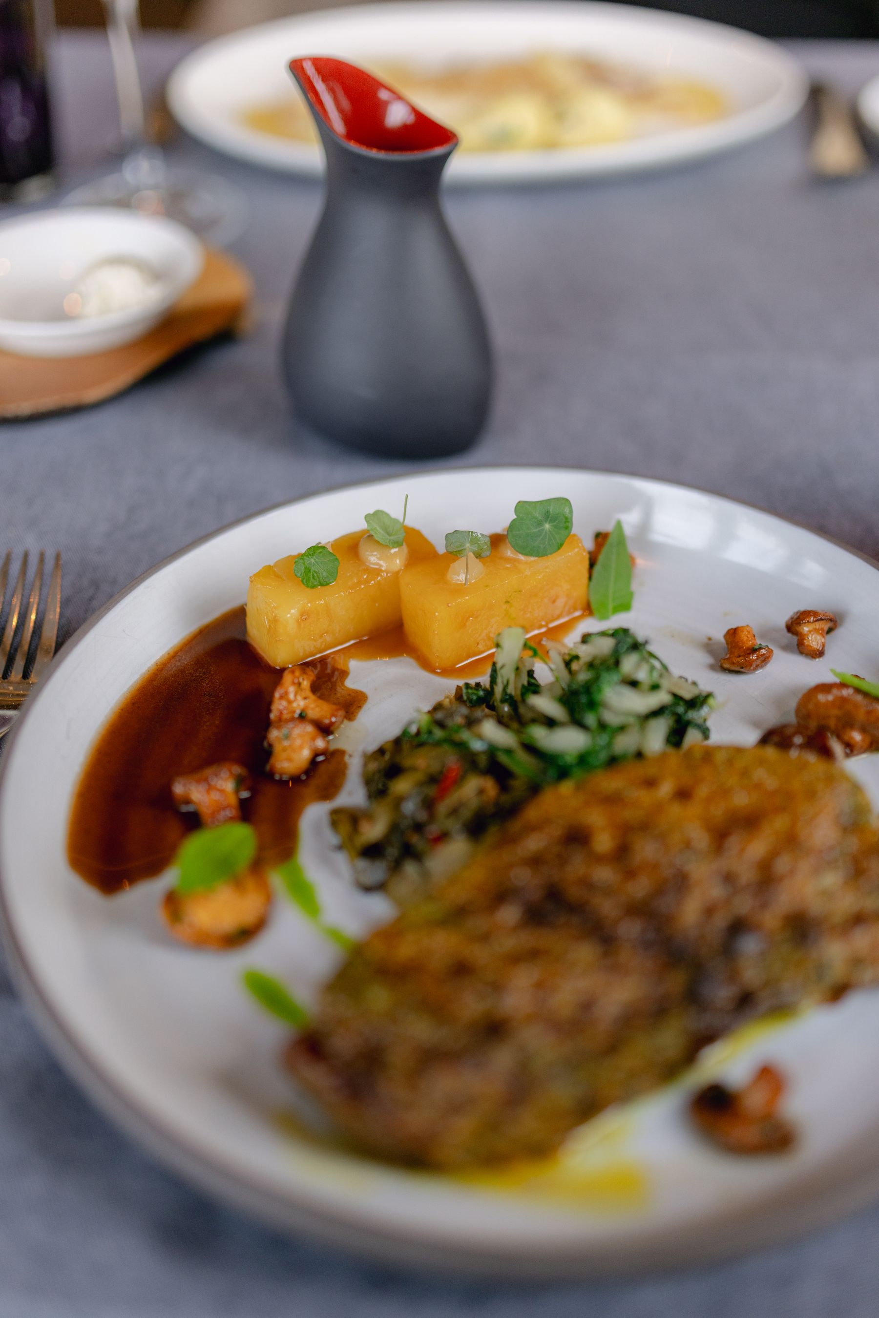 A plated main course with sauce and herbs